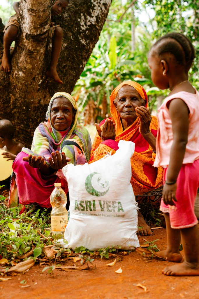 pexels-photo-30616681-30616681 Elderly women and child receiving aid package in rural setting.